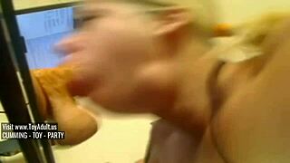The blonde practices deep throating with a large dildo.