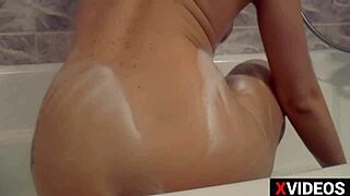 the cute wife gets soapy and slippery masturbating with a dildo in the bathroom, reaching orgasm