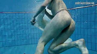 Dark haired teen Andrea floats in pool