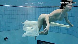 Dark haired teen Andrea floats in pool