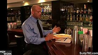 Hottie long-haired gay man with tattoos sucks big cock in office blowjob, leading to hardcore fucking and cumshot on bald guy at work