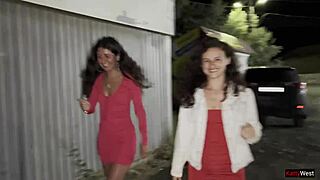 two girlfriends peeing together by the car in the public lot