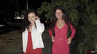 two girlfriends peeing together by the car in the public lot