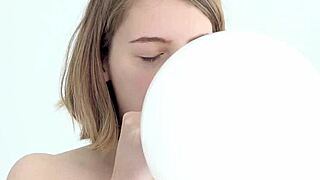 A young babe experiences blowing and popping her first balloon