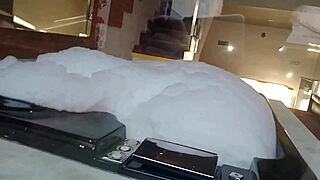 Spying on a brunette bathing, a guy in feminine clothing enters and they engage in intimate activities with her pear-shaped ass