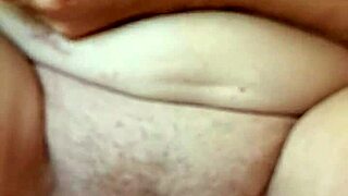 A mature woman plays with her pussy up close, talking dirty in a sexy voice