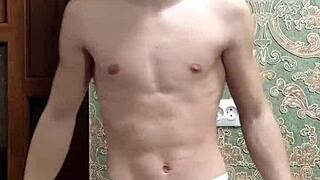 skinny boy flexes his muscles in underwear at home