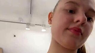 teen masturbates her wet pussy in the changing room, moaning as she reaches orgasm on webcam