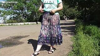 Hairy mature woman walks in see-through dress flashing beaver outdoors